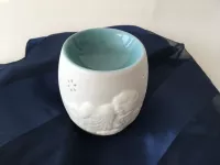 Aroma lampa „Ochranný anděl“ – porcelánová dekorace pro klid a harmonii Porcelánová aroma lampa Ochranný anděl v bílé barvě s reliéfem andělíčků na světlém pozadí