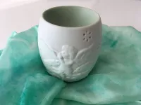 Aroma lampa „Ochranný anděl“ – porcelánová dekorace pro klid a harmonii Porcelánová aroma lampa Ochranný anděl v bílé barvě s reliéfem andělíčků na světlém pozadí“