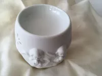 Aroma lampa „Ochranný anděl“ – porcelánová dekorace pro klid a harmonii Porcelánová aroma lampa Ochranný anděl v bílé barvě s reliéfem andělíčků na světlém pozadí