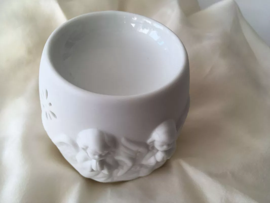 Porcelánová aroma lampa Ochranný anděl v bílé barvě s reliéfem andělíčků na světlém pozadí