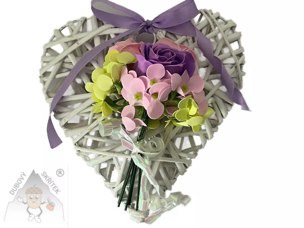 Bílé proutěné závěsné srdce zdobené fialovou růží, růžovými a zelenými květy a fialovou mašlí