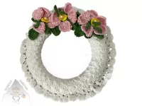 Háčkovaný bílý věneček zdobený růžovými šípkovými růžičkami a zelenými lístky – ruční dekorace