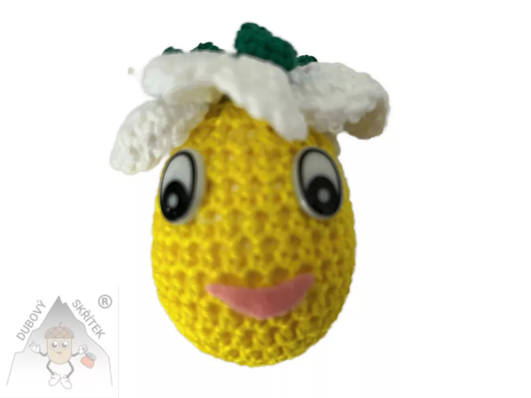 Háčkované vajíčko s veselým obličejem a háčkovanou květinou na vrchu, vytvořené jako jarní dekorace.