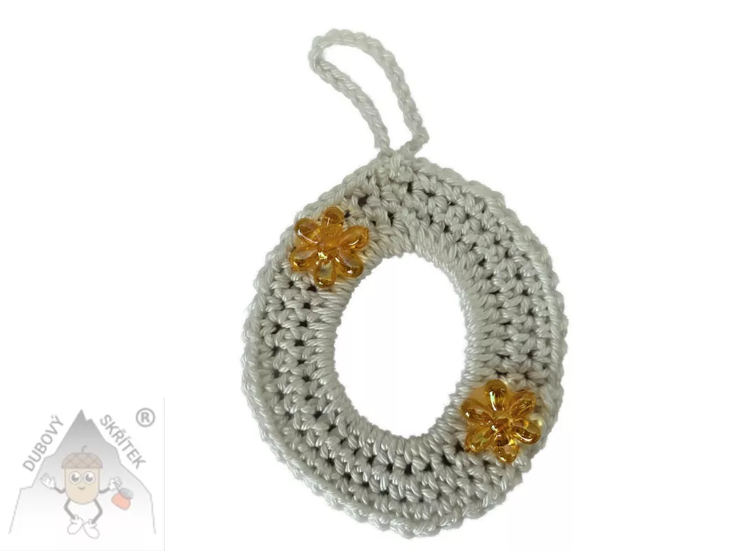 Háčkované vajíčko s poutkem na zavěšení, ozdobené dvěma třpytivými kvítky.