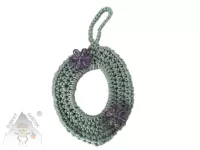 Háčkované vajíčko s poutkem na zavěšení, ozdobené dvěma třpytivými kvítky.