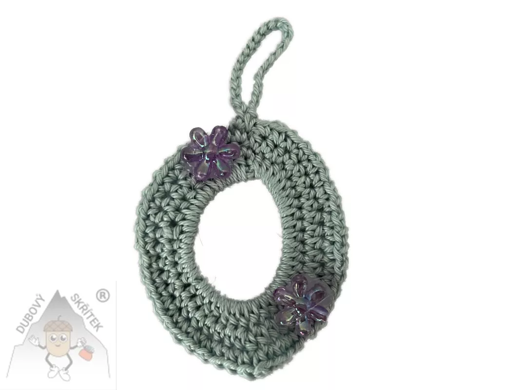 Háčkované vajíčko s poutkem na zavěšení, ozdobené dvěma třpytivými kvítky.