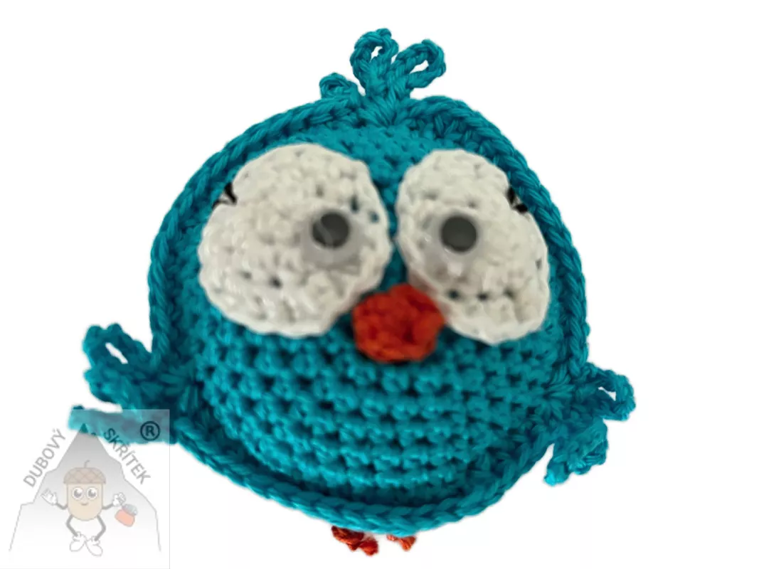 Veselý háčkovaný ptáček s výraznýma očima a drobnými křidélky, ručně vytvořený jako dekorace