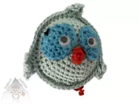 Veselý háčkovaný ptáček s výraznýma očima a drobnými křidélky, ručně vytvořený jako dekorace