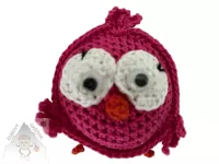 Veselý háčkovaný ptáček s výraznýma očima a drobnými křidélky, ručně vytvořený jako dekorace