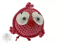 Veselý háčkovaný ptáček s výraznýma očima a drobnými křidélky, ručně vytvořený jako dekorace