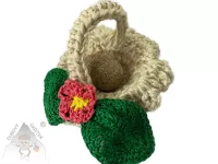 Háčkovaný jutový košík s tromlovaným kamenem ve tvaru vajíčka a háčkovanou mašlí – přírodní velikonoční dekorace